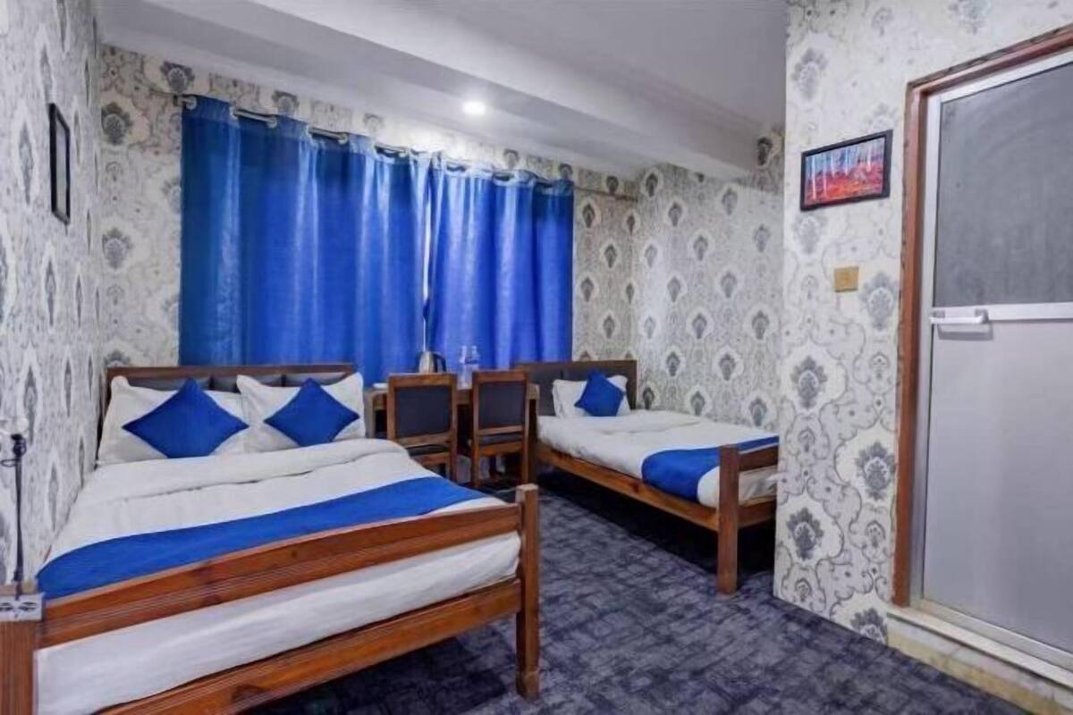 A room with two wooden beds, a desk, and a chair.