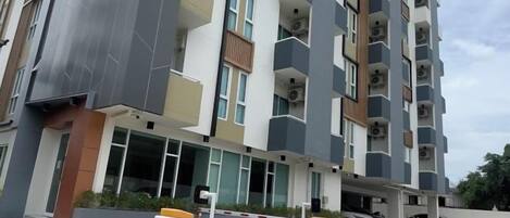 A multi-story residential building with balconies and a gated entrance.