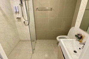 A bathroom with a glass shower enclosure, a toilet, and a sink with a mirror. - Sunrise good view @ East Ville Bangsaen (Chon Buri)