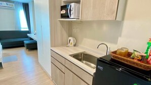 Una cocina compacta con un lavabo, un microondas y un refrigerador.