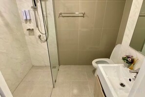 Une salle de bain avec une douche à parois de verre, des toilettes et un lavabo avec un miroir.
