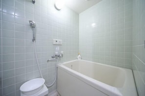 Un baño con bañera, inodoro y ducha.