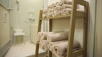 A wooden shelf with neatly folded towels in a bathroom.