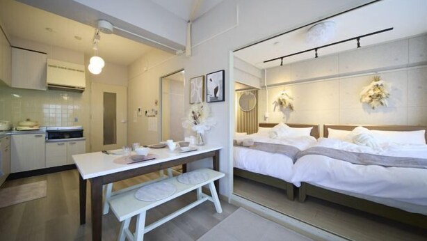 A modern hotel room with a bed, bedside table, and a small kitchenette. - Mezon Etowaru #706 (Nagoya)