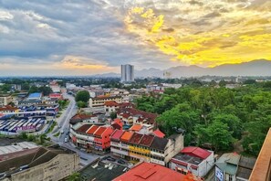 A cityscape with buildings, roads, and a sunset. - IPOH The Majestic Imperial Air-Con 6 PAX SUITE (Ipoh)