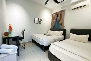 A hotel room with two beds, a desk, a chair, and an air conditioning unit. - IPOH The Majestic Imperial Air-Con 6 PAX SUITE (Ipoh)