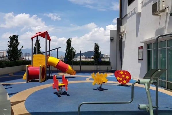 A children's play area with a slide, climbing structures, and exercise equipment. - IPOH The Majestic Imperial Air-Con 6 PAX SUITE (Ipoh)