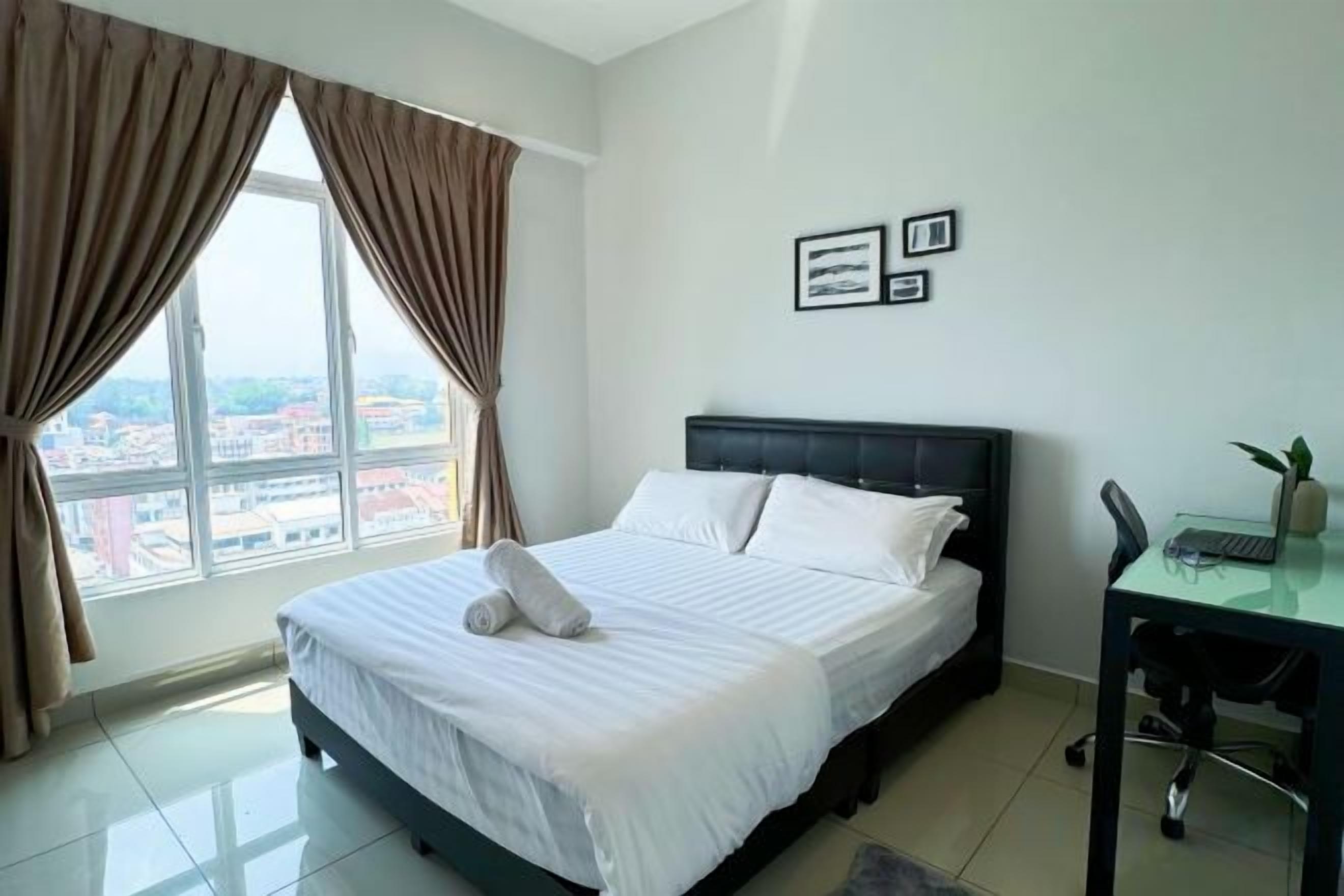 Una camera d'albergo con un letto grande, una scrivania e vista sulla città.