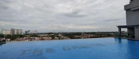 A rooftop pool with a view of a cityscape.