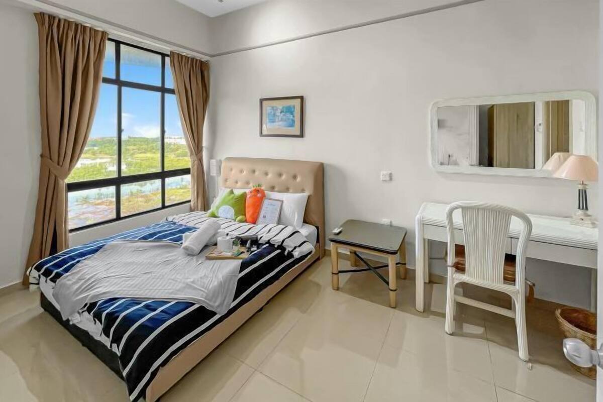 Ein Hotelzimmer mit Bett, Schreibtisch, Stuhl, Fenster mit Vorhängen und Spiegel.