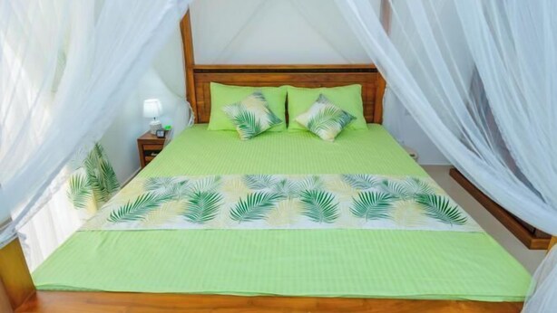 A bed with a canopy, a nightstand, and a lamp. - The Hideout - 2Br Villa Near Kahathuduwa Interchange (Polgasowita)