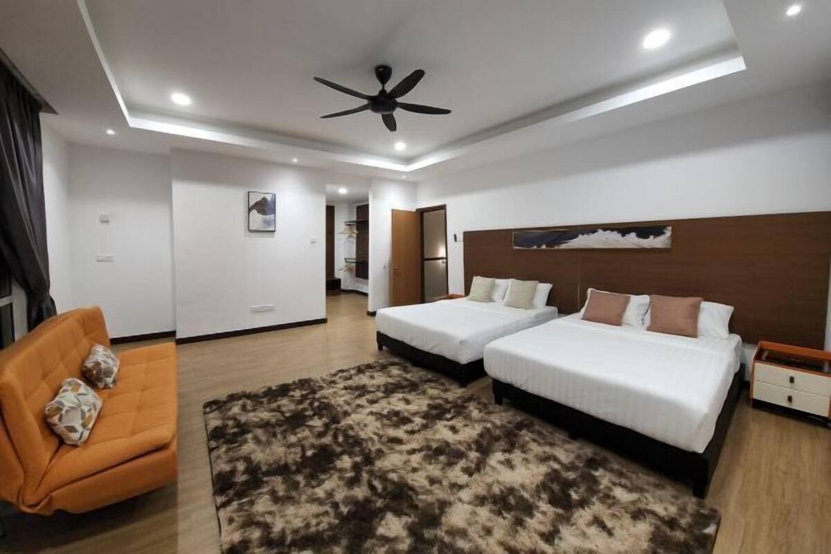 A modern hotel room with two beds, a ceiling fan, and a large rug.