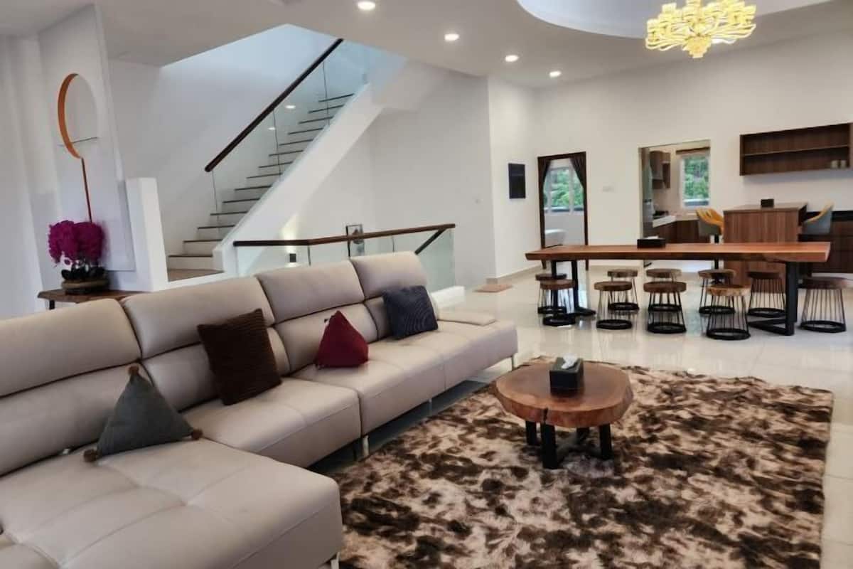 A modern living room with a sofa, coffee table, and a staircase leading to an upper level.