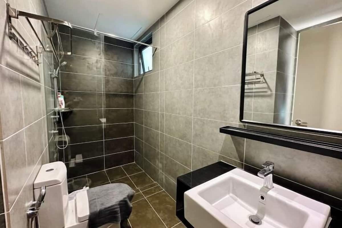 A modern bathroom with a shower, a sink, and a mirror.