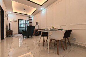 A dining area with a table, chairs, and a chandelier. - WHITE ON HOMESTAY CAMERON BY ICOLOR (Tanah Rata)