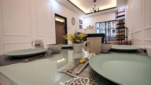A dining area with a long table, chairs, and a chandelier. - WHITE ON HOMESTAY CAMERON BY ICOLOR (Tanah Rata)