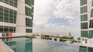 A rooftop infinity pool with clear water, surrounded by modern buildings and a view of the sea. - The Panoramic Duplex Glass Suite @ Karpal Singh Drive Georgetown, Penang. (Jelutong)