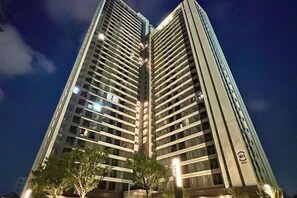 A high-rise building with multiple floors, illuminated windows, and a clear sky. - R Residence (Phnom Penh)