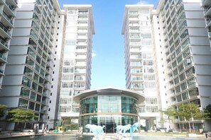 A modern high-rise building with a central glass atrium and a swimming pool area. - Emgrace/Near AeonTebrau/ IKEA Toppen /MountAustin (Johor Bahru)