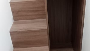 Un escalier en bois, doté d’une rampe, menant à un espace intérieur.
