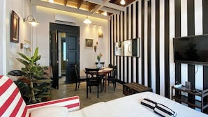 A hotel room with a bed, a TV, a desk with a chair, and a dining table. - Luxury Thai Design Home – Chinatown Self Check In (Bangkok)