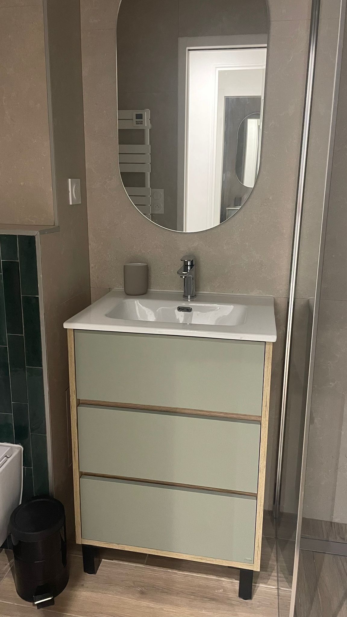A bathroom with a white sink, a mirror, and a cabinet with drawers.