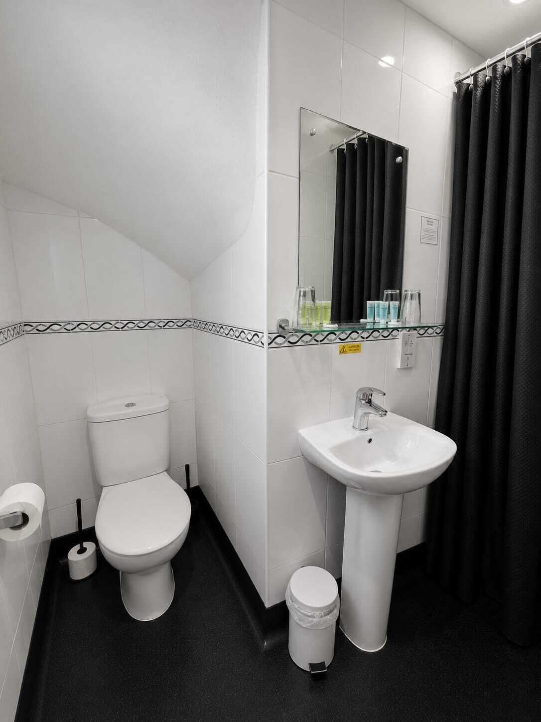 A modern bathroom with a toilet, sink, and mirror.