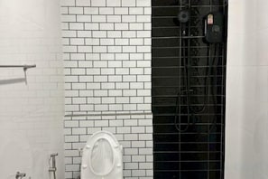 A bathroom with white tiled walls, a white toilet, and a black shower enclosure. - Huather Villa & Cafe (Lang Suan)