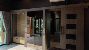 A modern room with a bed, a desk, and a view of the outdoors. - Huather Villa & Cafe (Lang Suan)