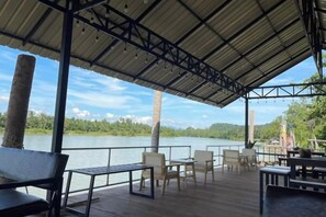 An outdoor deck with seating and a view of a lake.