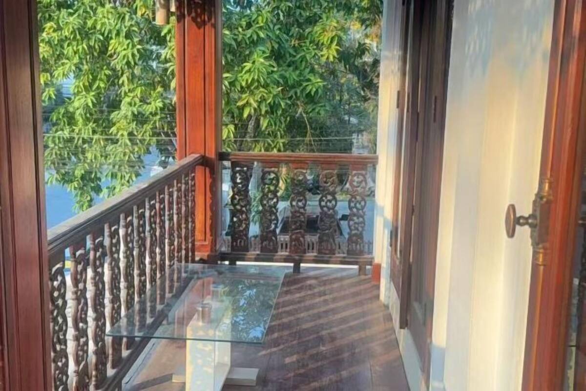 A wooden balcony with intricate railings and a glass floor.