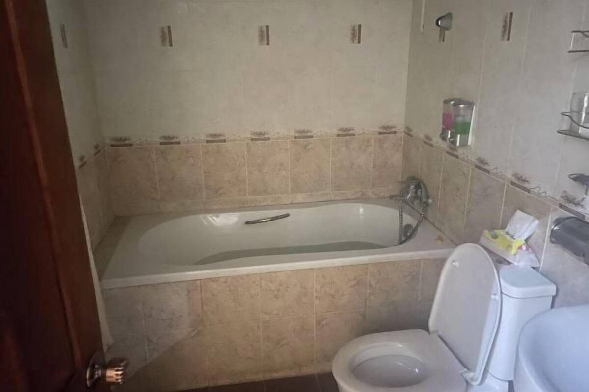 A bathroom with a bathtub, toilet, and a shower area.