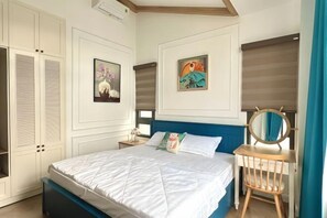 Une chambre à coucher comprenant un lit, une table de chevet, une commode, un miroir et une fenêtre avec des stores.