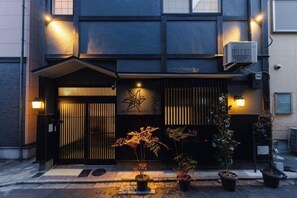 A building with a dark facade, a star-shaped decoration, and potted plants at the entrance. - Kyoto Amazing The Wizarad of Oz (Kyoto)