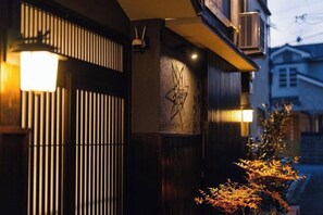 A building facade with vertical slats and a wall-mounted sculpture. - Kyoto Amazing The Wizarad of Oz (Kyoto)