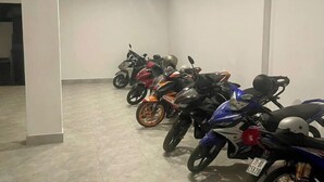 A row of motorcycles parked indoors with a tiled floor and white walls. - Phu Gia 2307 Huynh Tan Phat (Ho Chi Minh City)