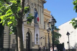 Un edificio histórico con arquitectura clásica, que incluye ventanas de arco y molduras decorativas.