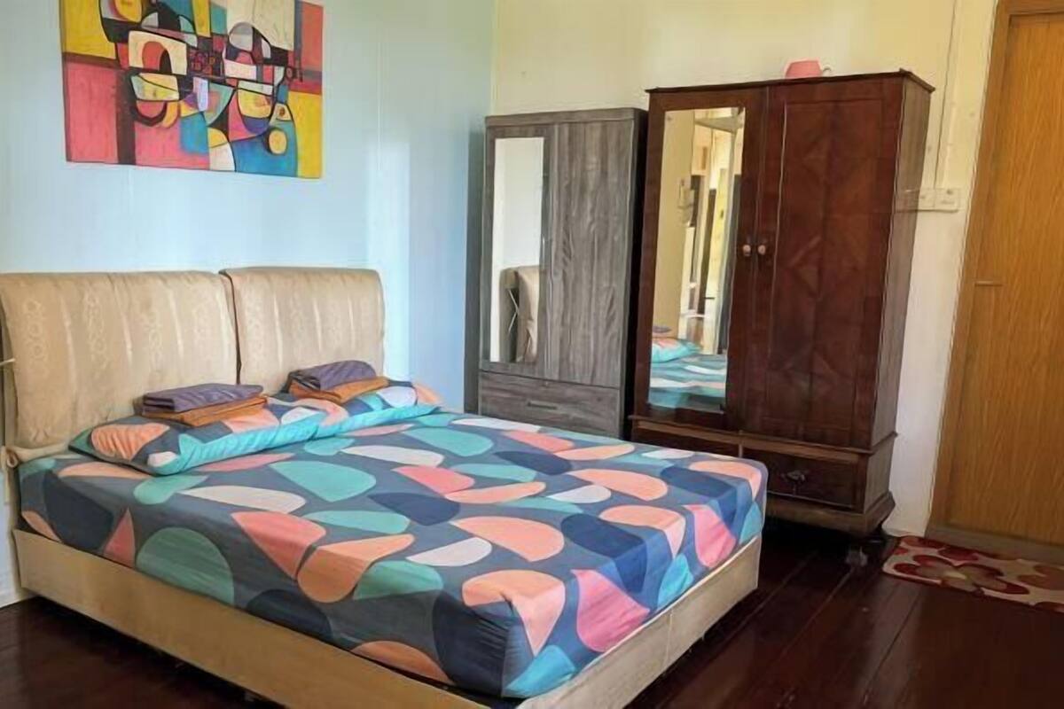 Ein Schlafzimmer mit Bett, Kleiderschrank und Spiegel.