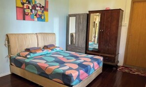 Ein Schlafzimmer mit Bett, Kleiderschrank und Spiegel.