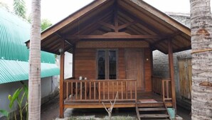A wooden structure with a porch, a door, and a small window.