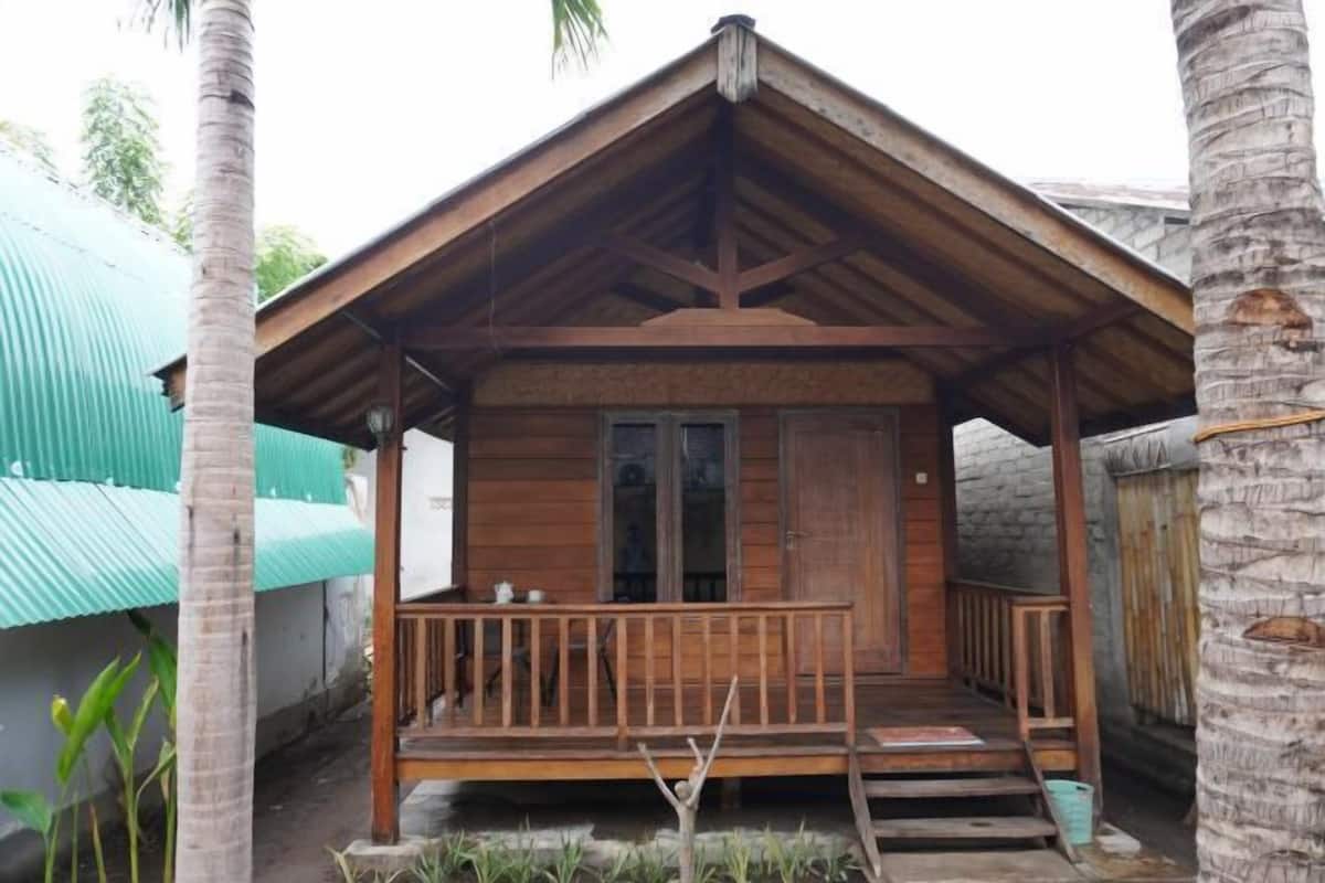 A wooden structure with a porch, a door, and a small window.