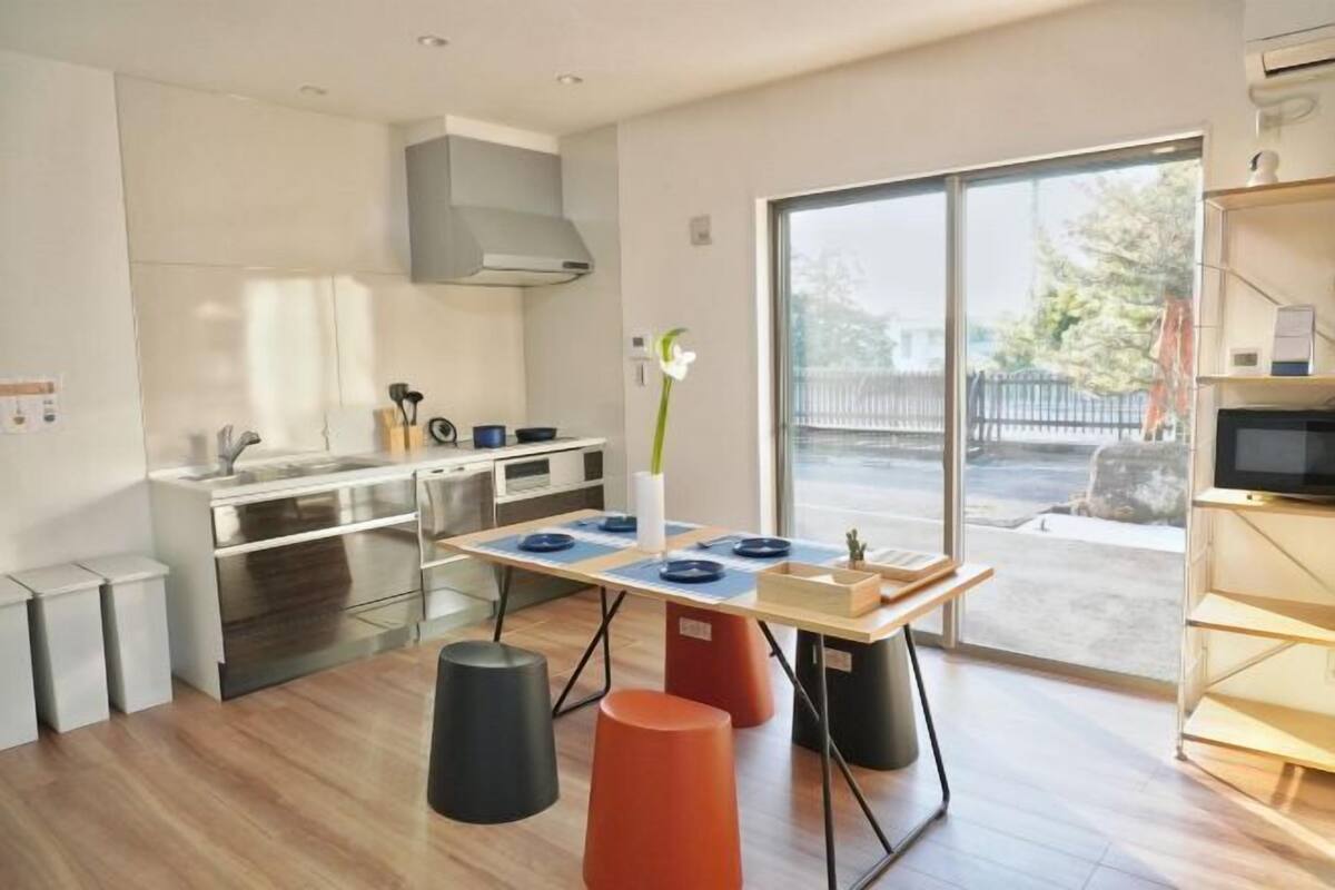 Een moderne keuken met een eetgedeelte, een groot raam en een televisie.