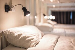 Una habitación de hotel con cama, lámpara de pared y vista a otra habitación.