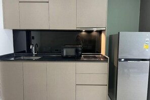 A modern kitchen with a stainless steel refrigerator, a toaster, and a sink.