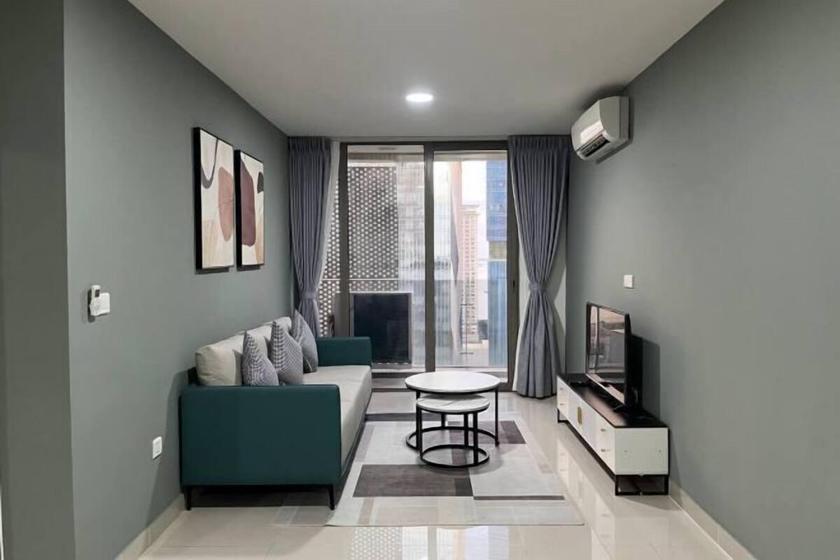 A modern living room with a sofa, a TV, and a dining table.