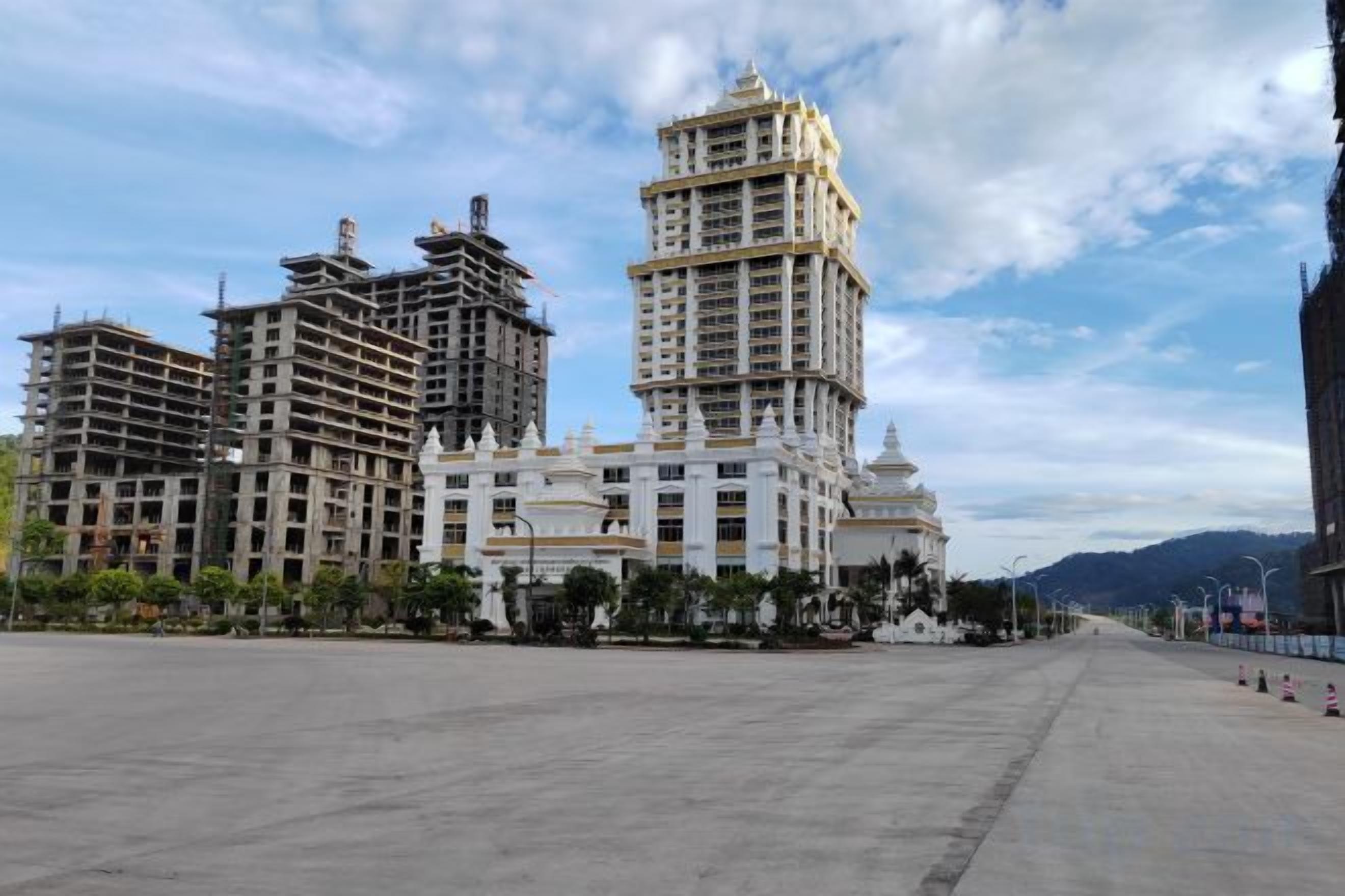 A large hotel complex with multiple high-rise buildings, a spacious plaza, and a clear sky.