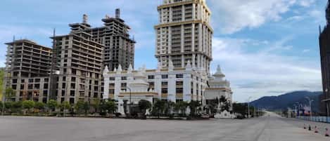 A large hotel complex with multiple high-rise buildings, a spacious plaza, and a clear sky.