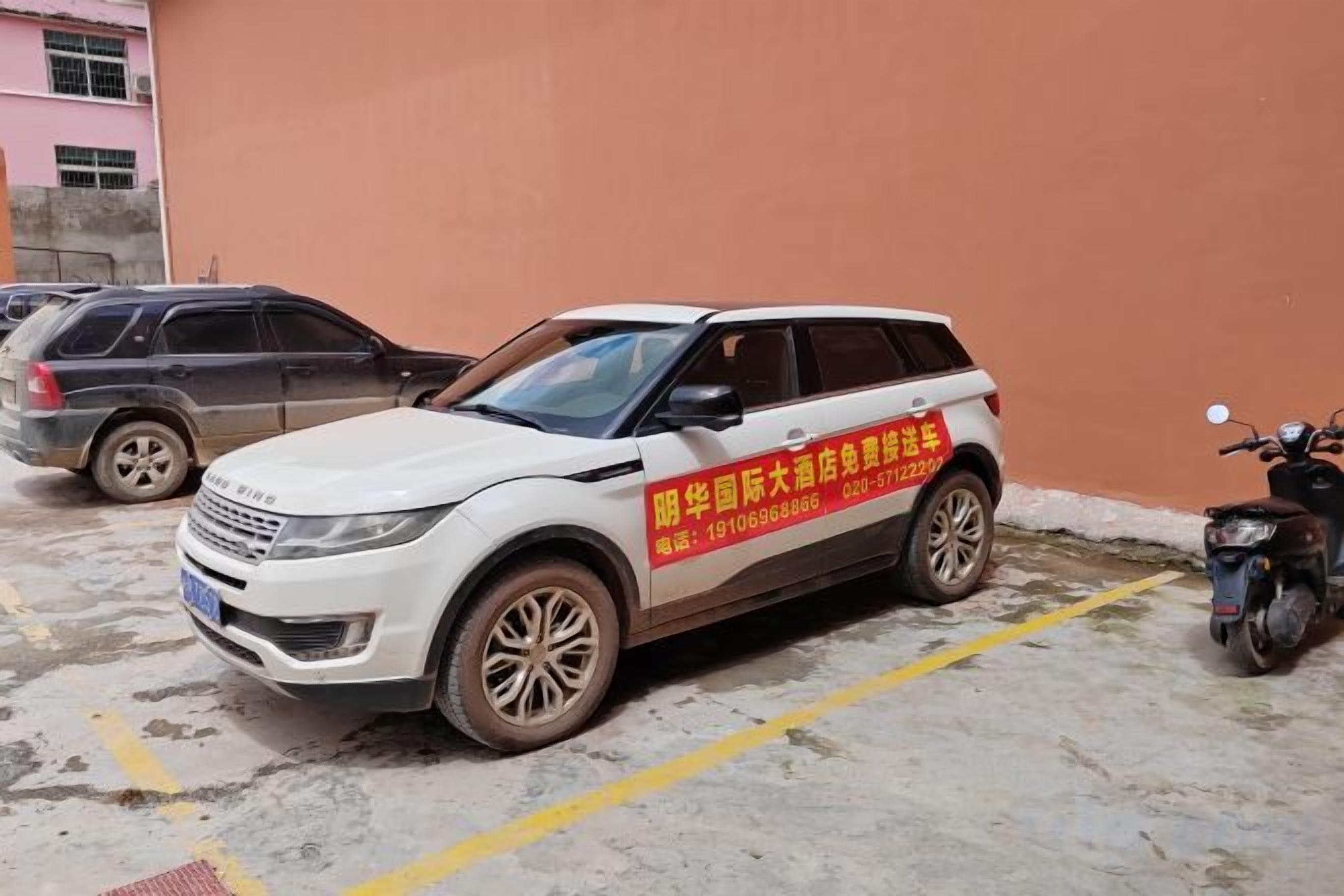 A white SUV parked in a parking lot with a yellow line marking.