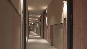 A hotel corridor with a carpeted floor, wooden paneling on the walls, and recessed lighting. - Hotel 1900 Express @ Chinatown (Short Overnight, 15 Hours, 6PM-9AM) (Singapore)