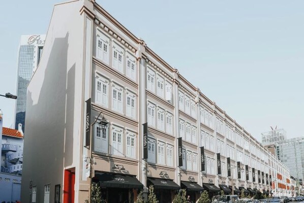 A row of white buildings with uniform architectural style, featuring multiple windows and awnings.